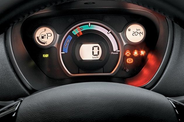 Шкала из «кирпичиков» слева — указатель уровня заряда, в правом кружочке — дисплей маршрутного компьютера. Зеленая надпись Ready вспыхивает при повороте ключа «зажигания». Стрелочный эконометр бесполезен — суматошные метания стрелки просто отражают степень нажатия педали «тока»