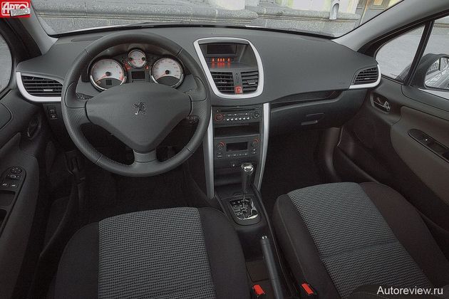 Салон Peugeot элегантен, но мягкий пластик — только выше пояса. Заплывшие на обивку дверей «ушки» передней панели зрительно делают салон просторнее