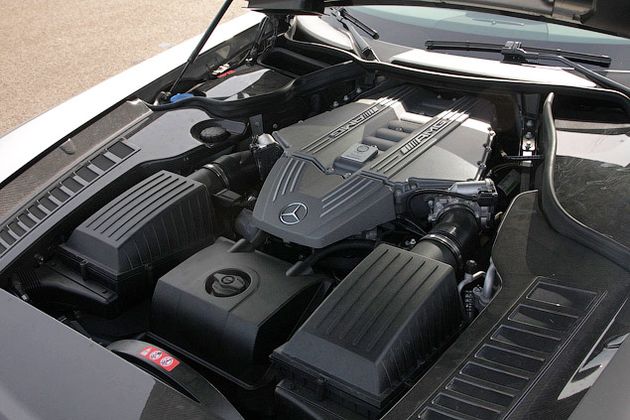 Под почти двухметровым капотом SLS AMG находится восьмицилиндровый двигатель с углом развала цилиндров 90 градусов, который расположен за передней осью и очень низко, на самом "полу"