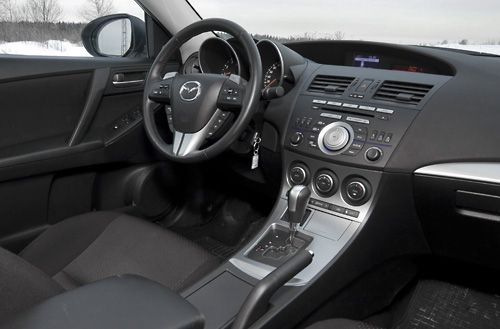 Салон в сравнении с предыдущим поколением значительно преобразился, как по тактильным, так и по визуальным ощущениям. Приятный пластик, сборка без огрехов. Сиденья правильной анатомической формы, вот только их жёсткость хороша лишь с одной стороны — не будет сколиоза. В долгих же поездках спина начинает ныть. Да и боковая поддержка лишь визуальная — валики расставлены очень широко. Салон Мазды вообще снисходительно относится к габаритным пассажирам — места достаточно и спереди, и сзади. Да и в багажнике, при желании, можно кого-нибудь разместить — там 430 комфортных литров и проём большой