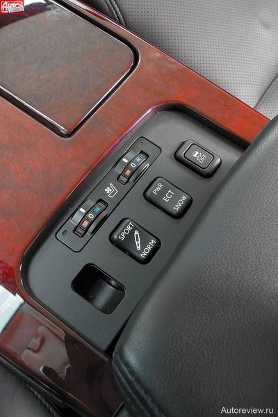 Барабанчики включения подогрева кресел и кнопки, заведующие отключением системы стабилизации, дополнительными режимами «автомата» и жесткостью подвески, в Лексусе спрятаны под сдвижным подлокотником