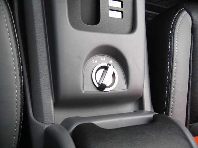 Рычаг переключения режимов работы полноприводной трансмиссии уступил место небольшой ''крутилке''. Между режимами 2H и 4H можно переключаться на скорости, но для включения понижайки придется остановиться и перевести КПП в нейтраль