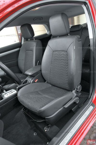 Несмотря на тиснение ткани под шинный протектор, сиденья совсем неспортивные — с широкими валиками и установлены они высоко