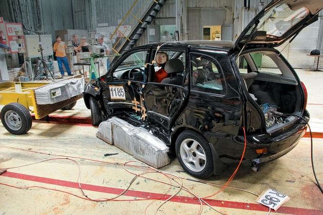 Центр удара 950-килограммовой тележкой приходится на так называемую точку R (теоретический центр вращения бедер водителя относительно туловища). Он не совпадает с центром масс автомобиля, и поэтому Калину разворачивает во время краш-теста вокруг более тяжелого передка